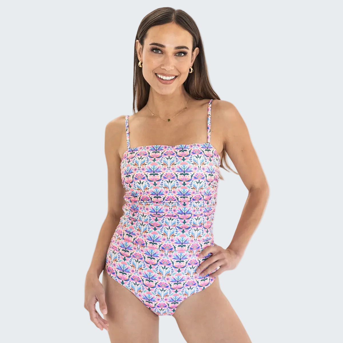 Woman wearing a floral one-piece swimsuit on a white background