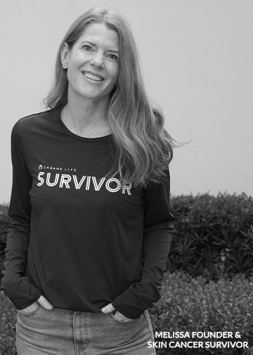Woman wearing a black shirt with 'Survivor' printed on it, standing outdoors.