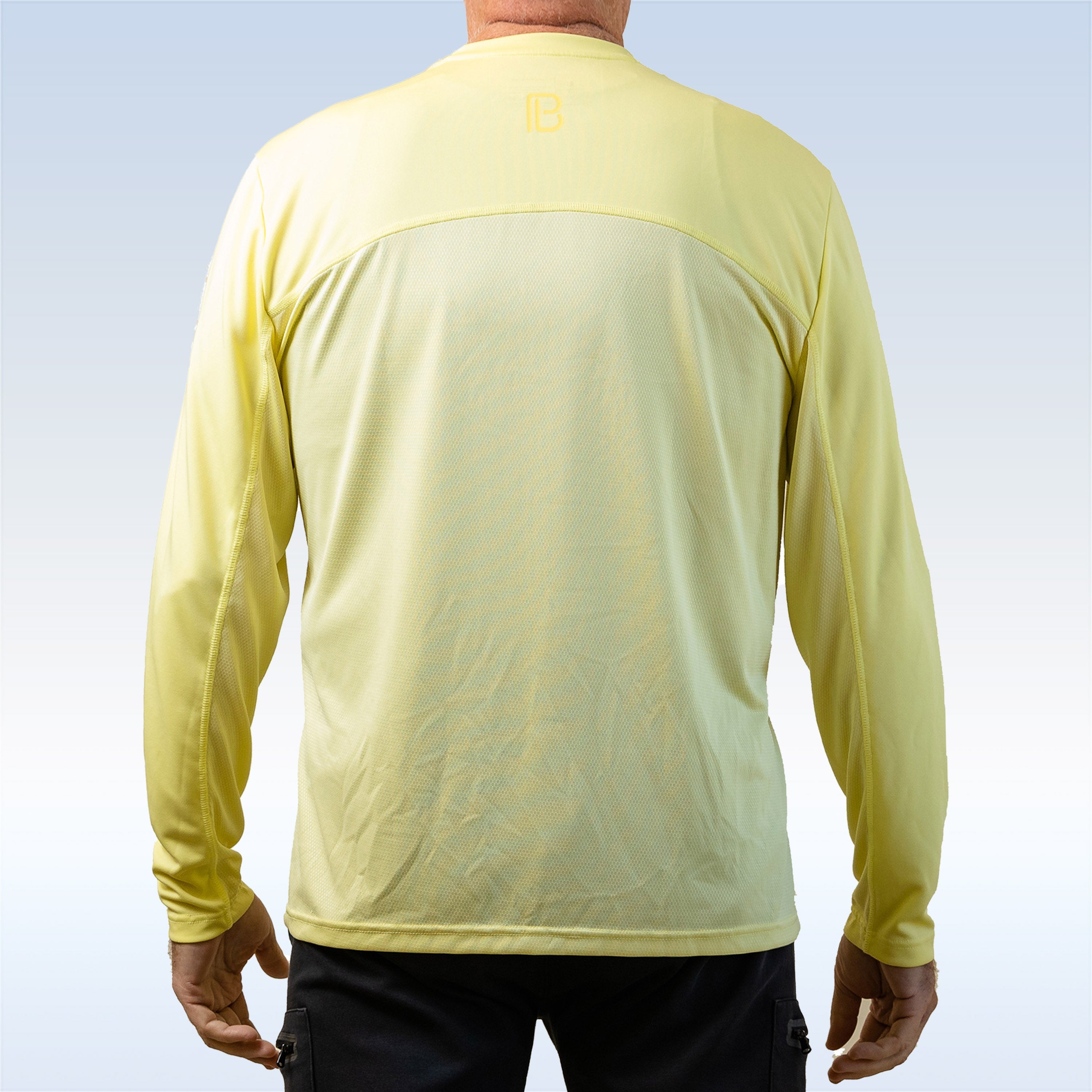 Person wearing a light yellow long-sleeve shirt with a subtle pattern on the back against a light blue background.