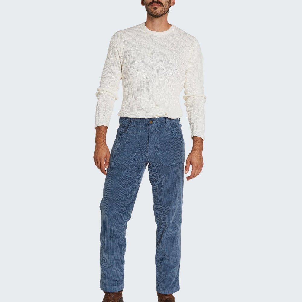 Man wearing a white sweater and blue pants on a white background