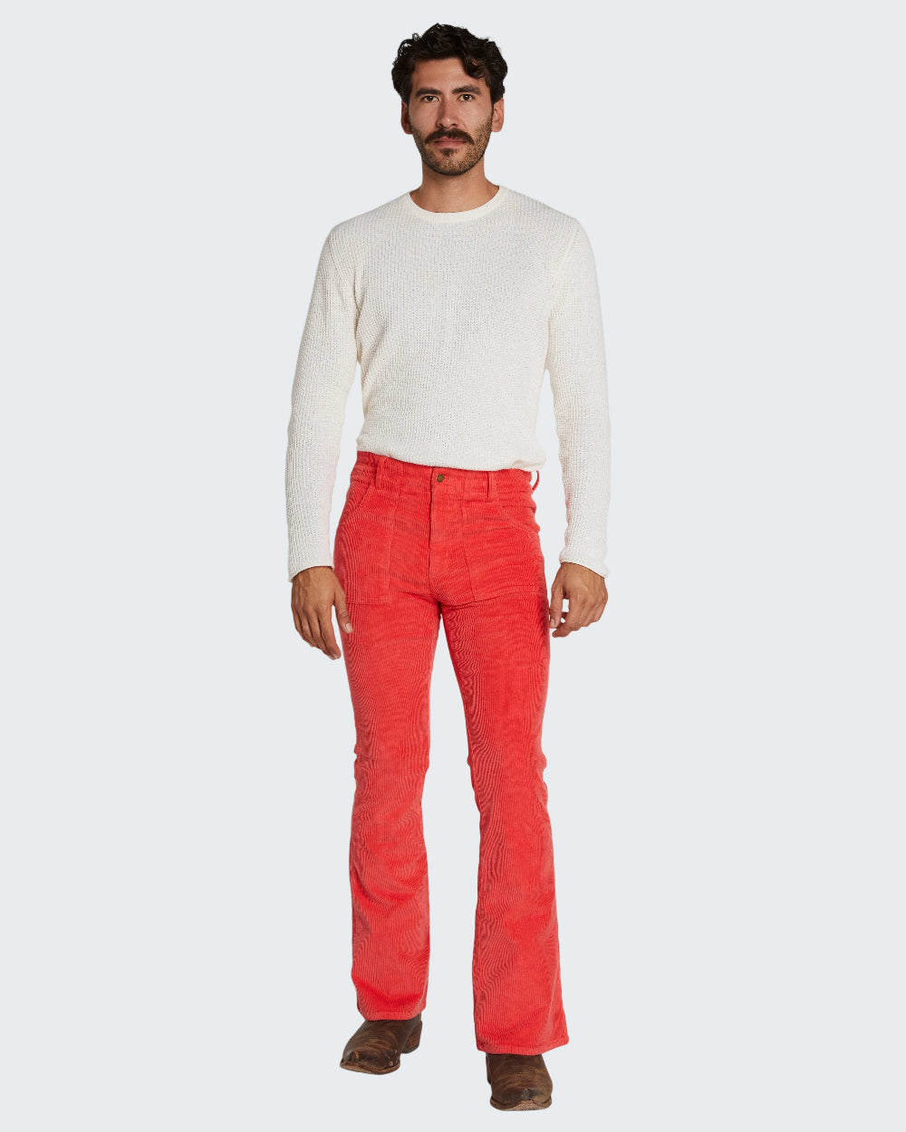 Man wearing a white long-sleeve shirt and red pants on a white background