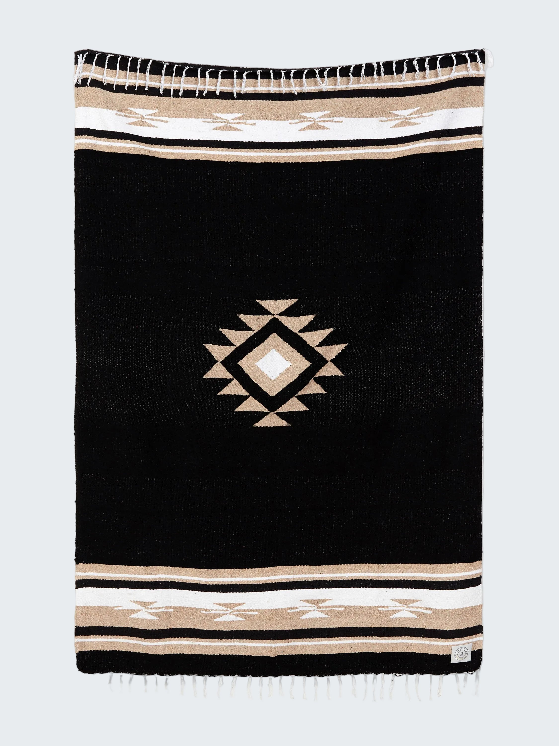 Black blanket with geometric pattern and striped border on a white background