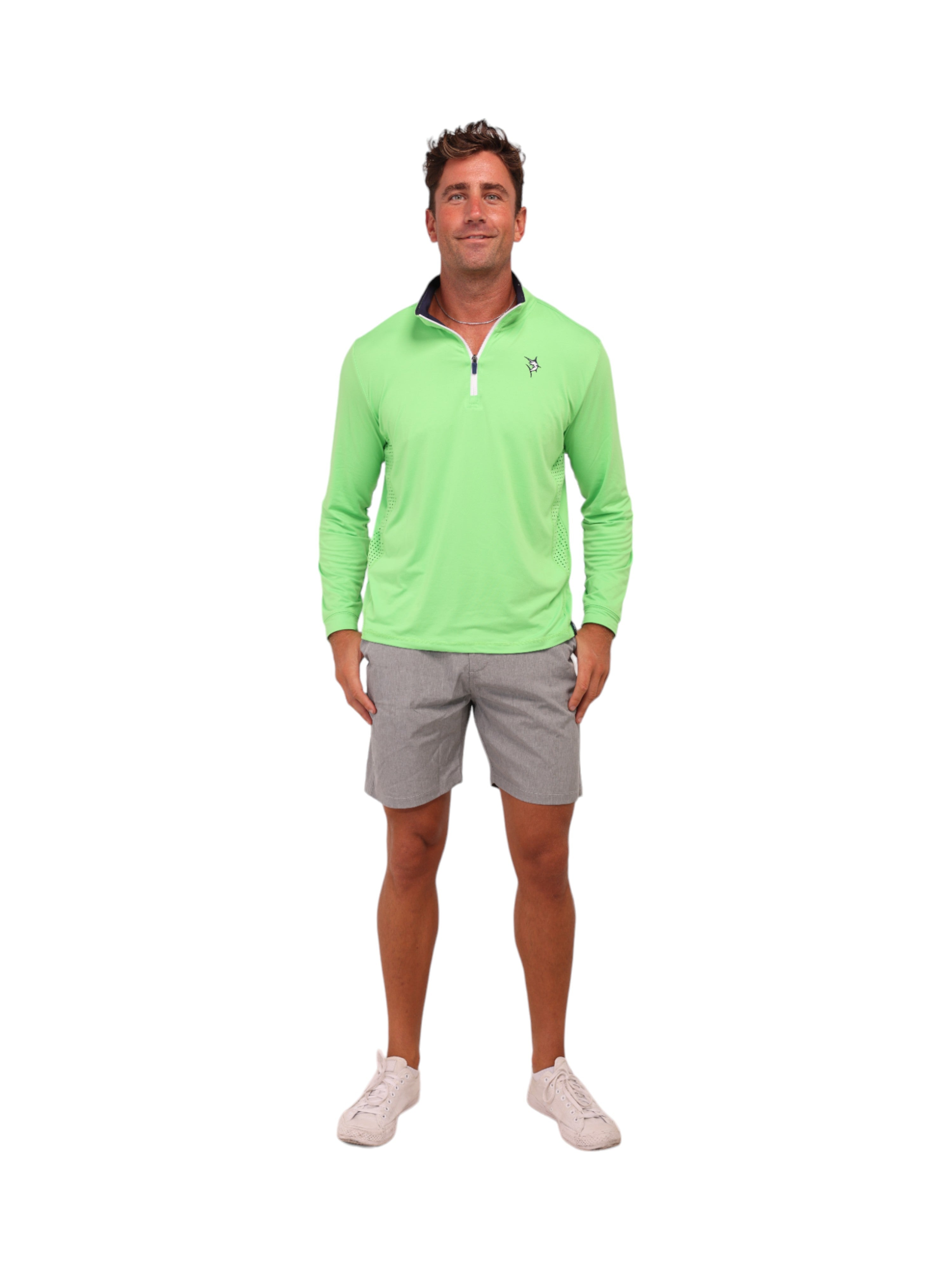 Man wearing a bright green long-sleeve shirt and gray shorts on a white background