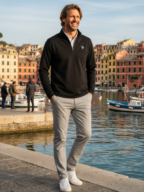 Man standing by a waterfront with colorful buildings in the background