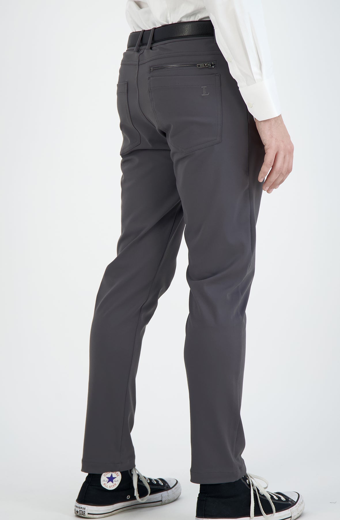 Person wearing gray pants with a white shirt on a white background
