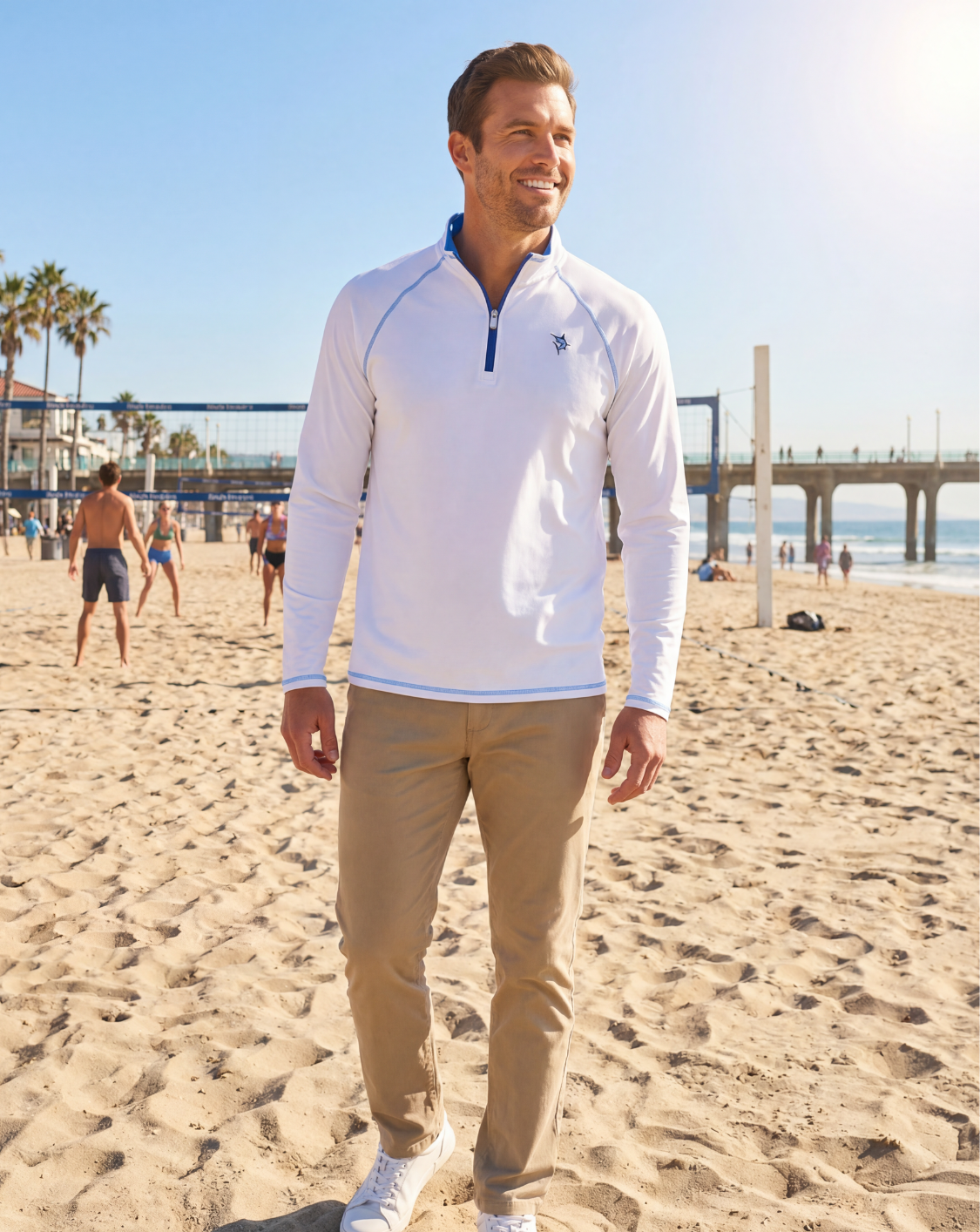 Man wearing a white pullover with a blue zipper on a beach