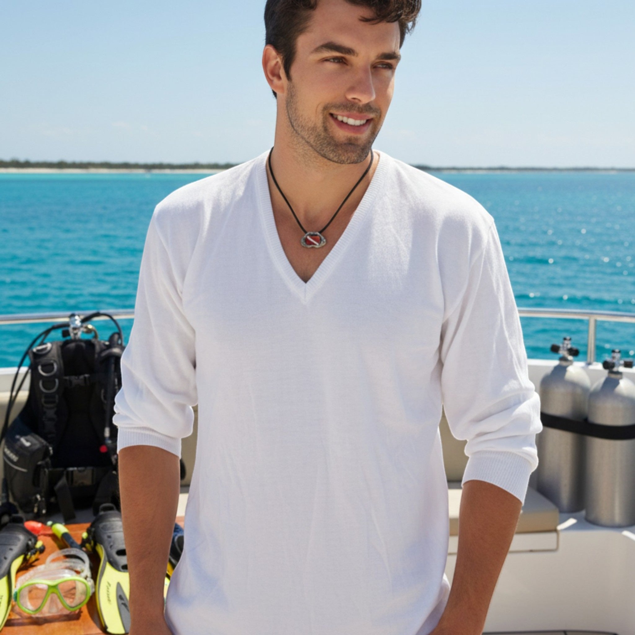 Man in a white shirt standing on a boat with water and clear sky in the background