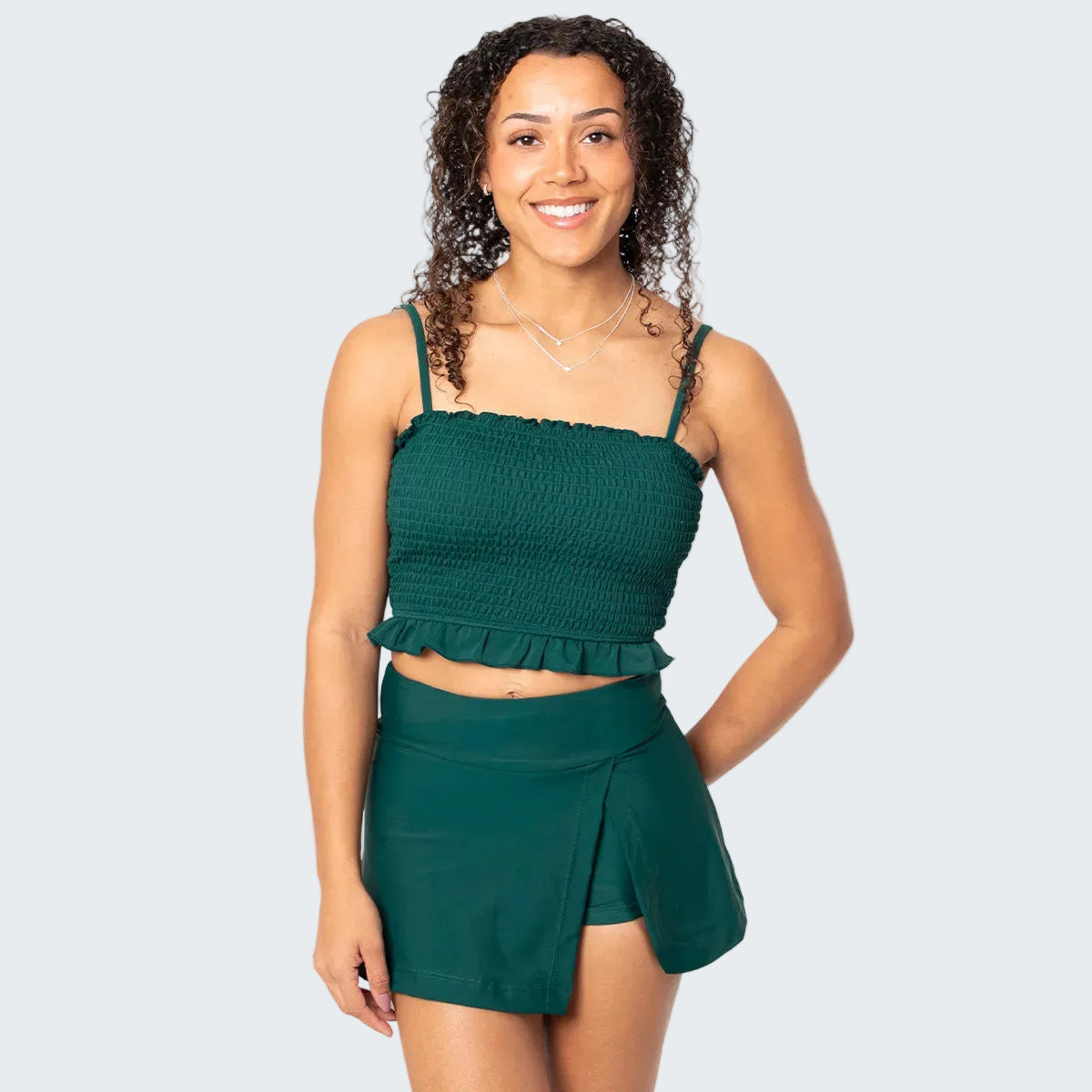 Woman wearing a green top and skirt set on a white background