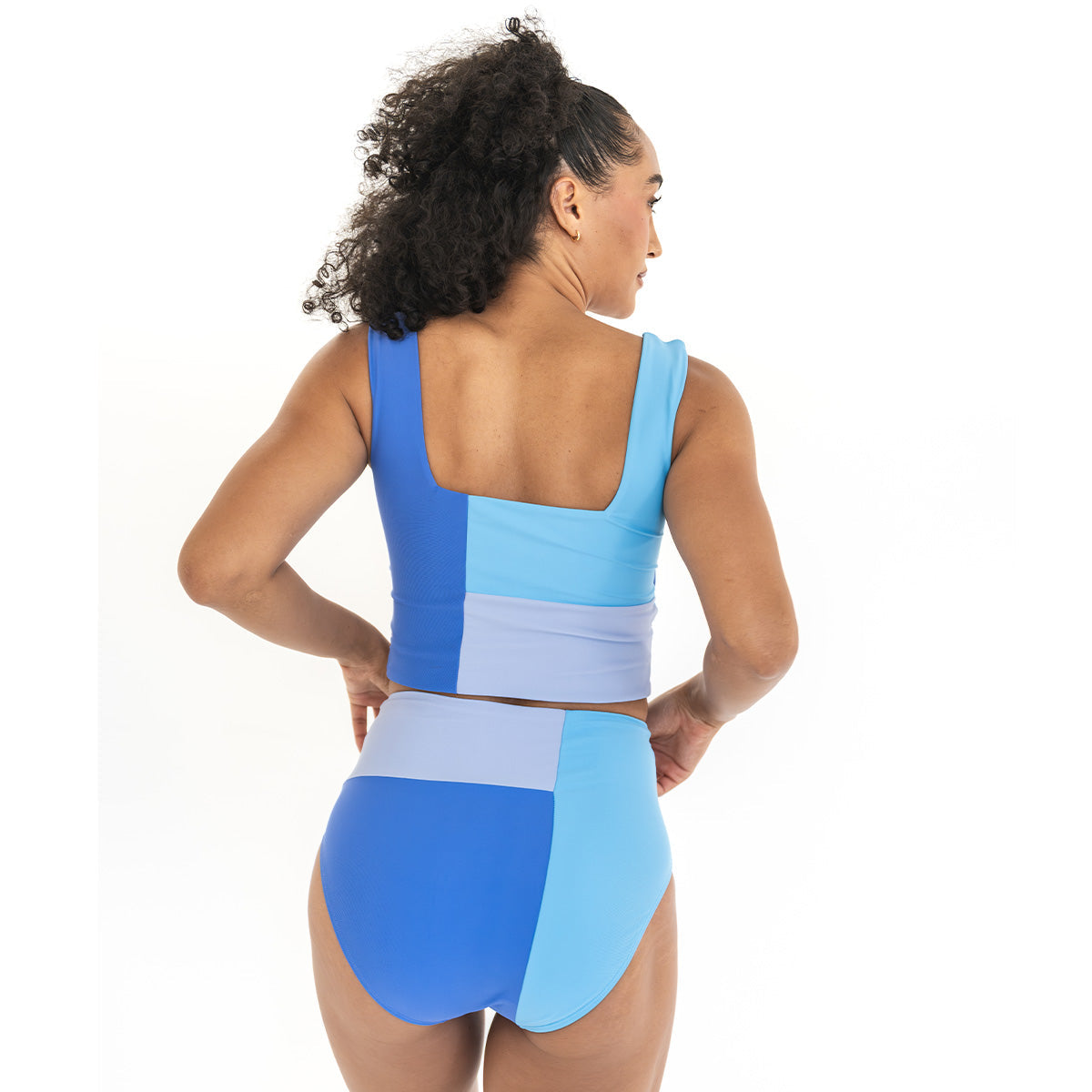 Woman wearing a blue and light blue swimsuit with a white background