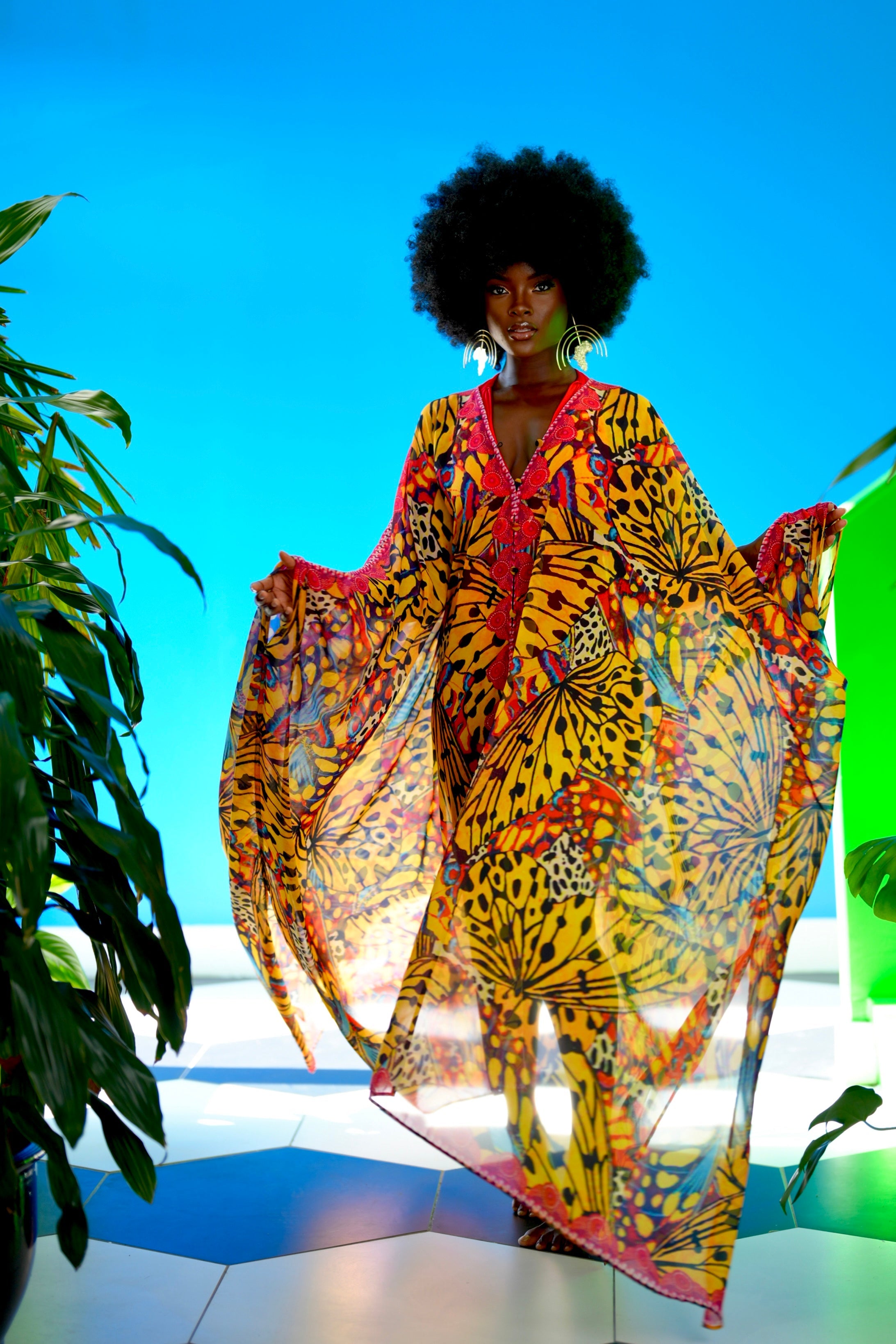 Woman wearing a colorful patterned dress against a blue background
