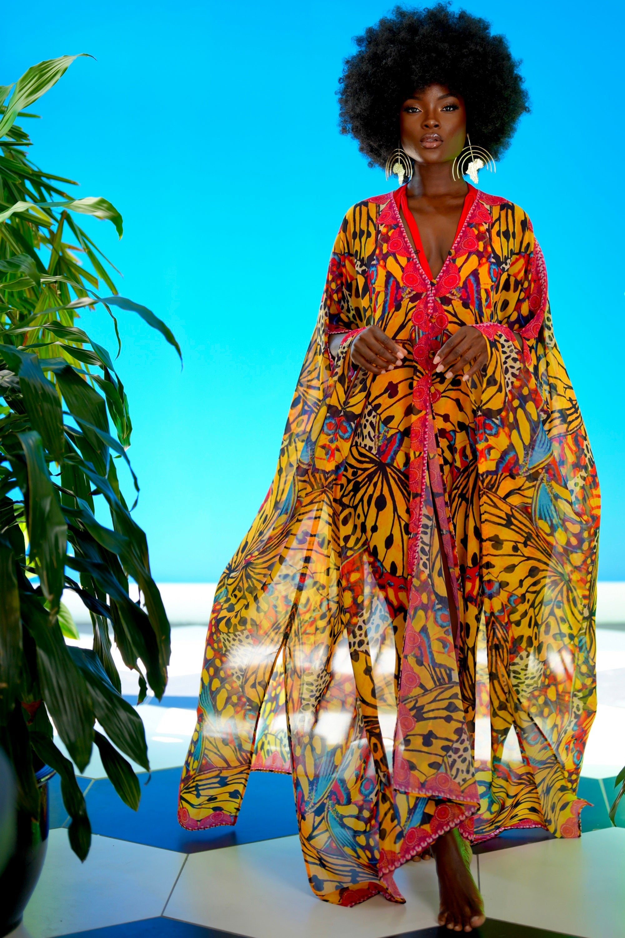 Woman wearing a colorful tiger print outfit against a blue sky.