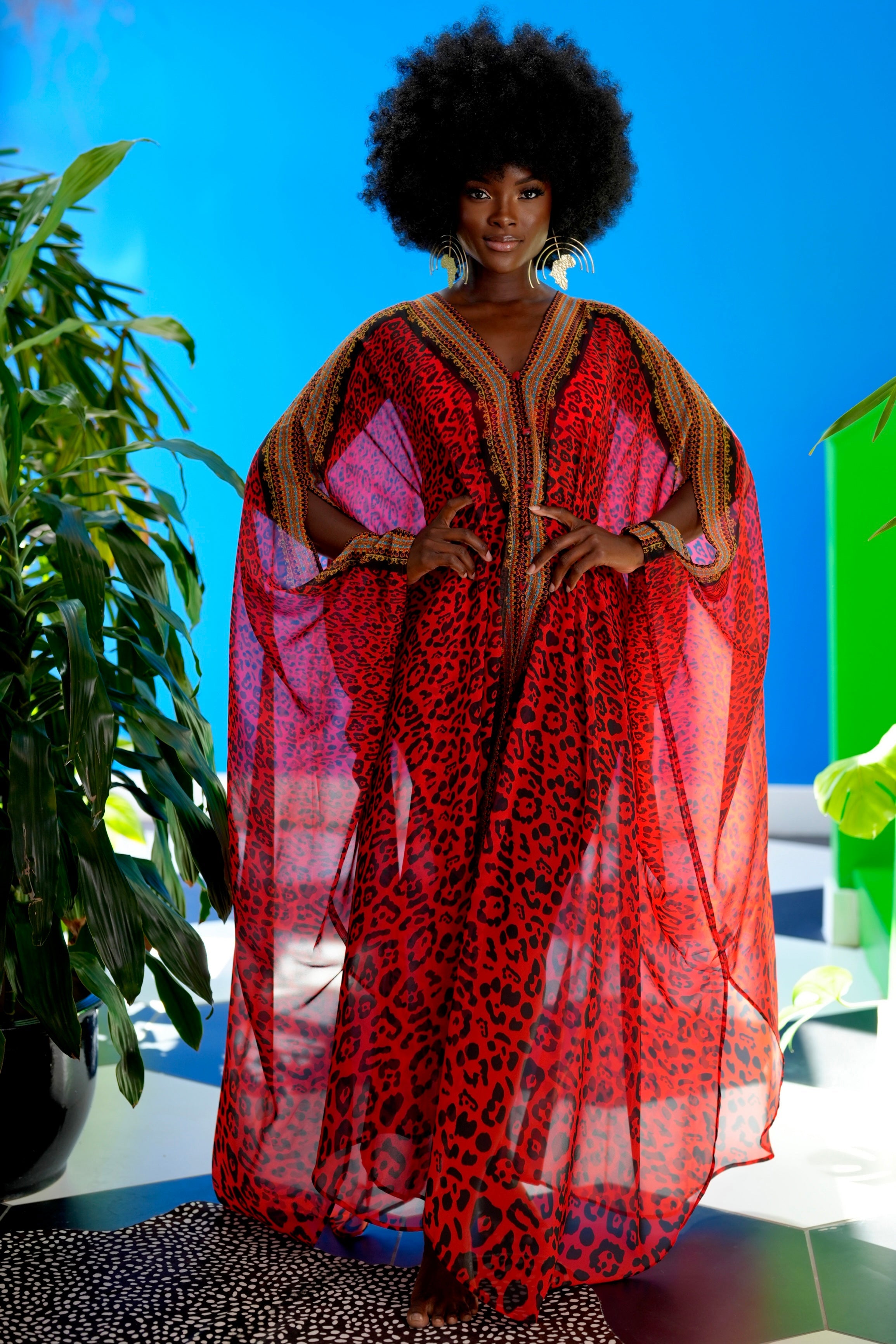 Woman wearing a red and brown patterned dress with a blue background