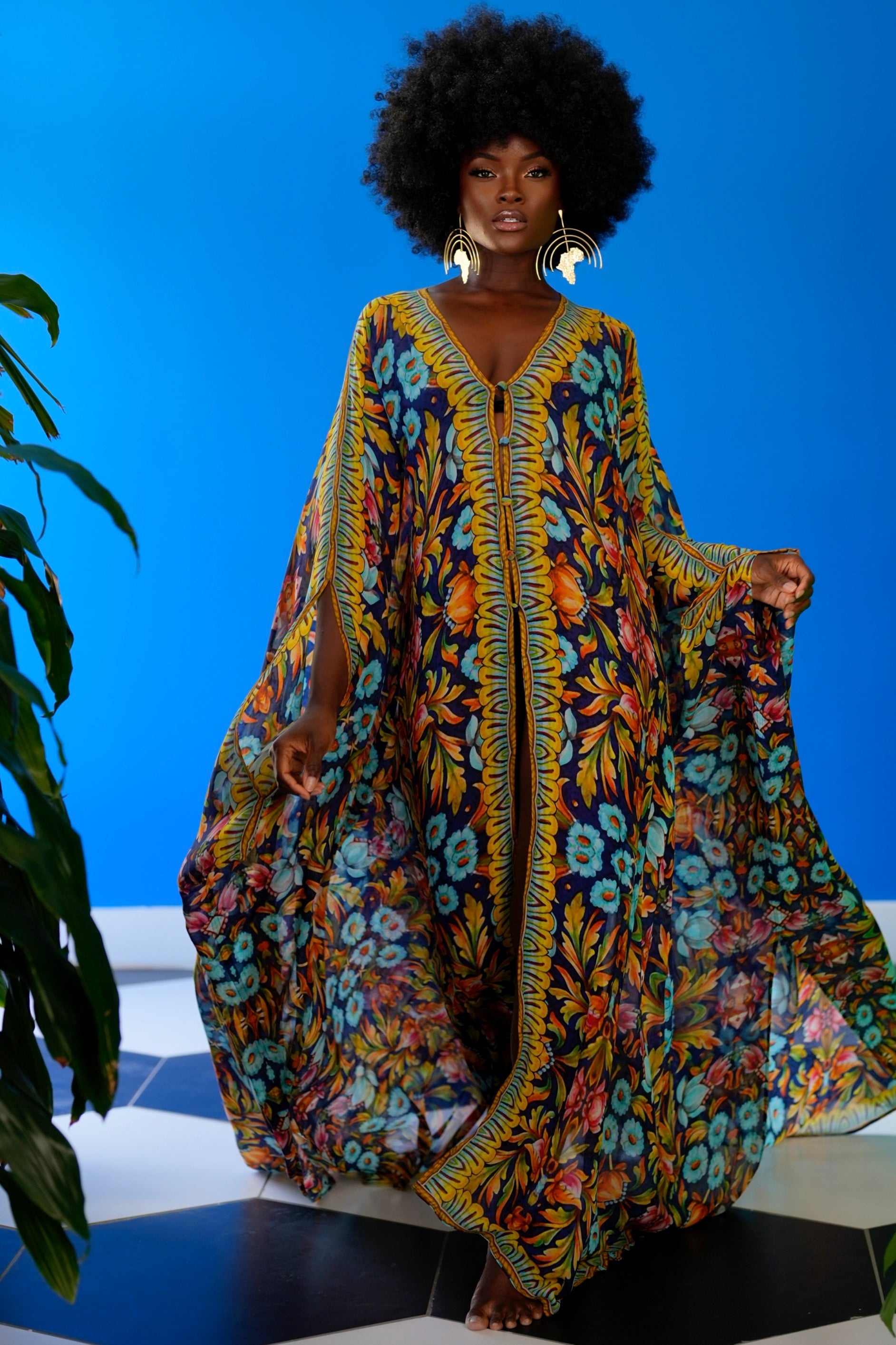 Woman wearing a colorful patterned dress against a blue background