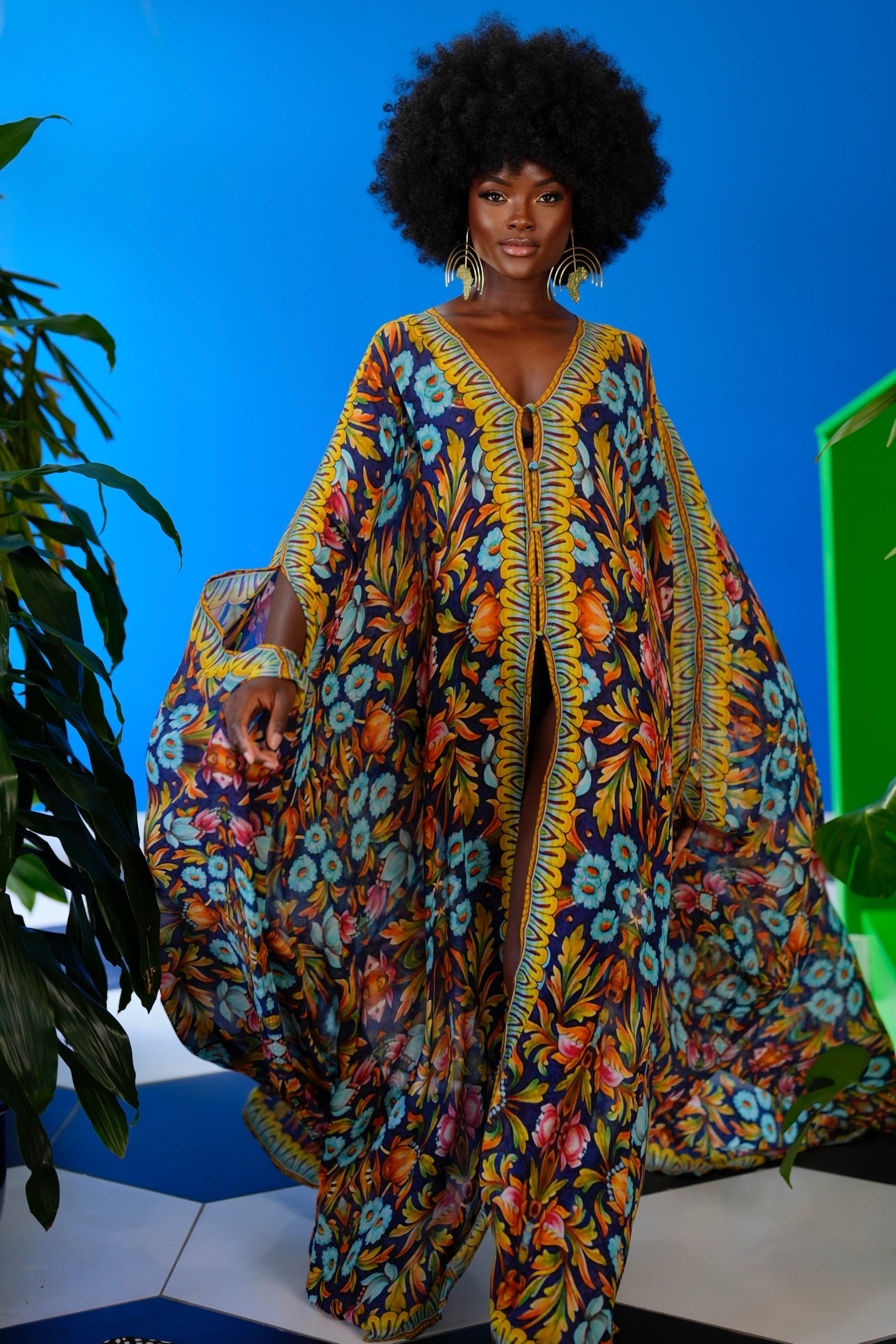 Woman wearing a colorful floral dress against a blue background