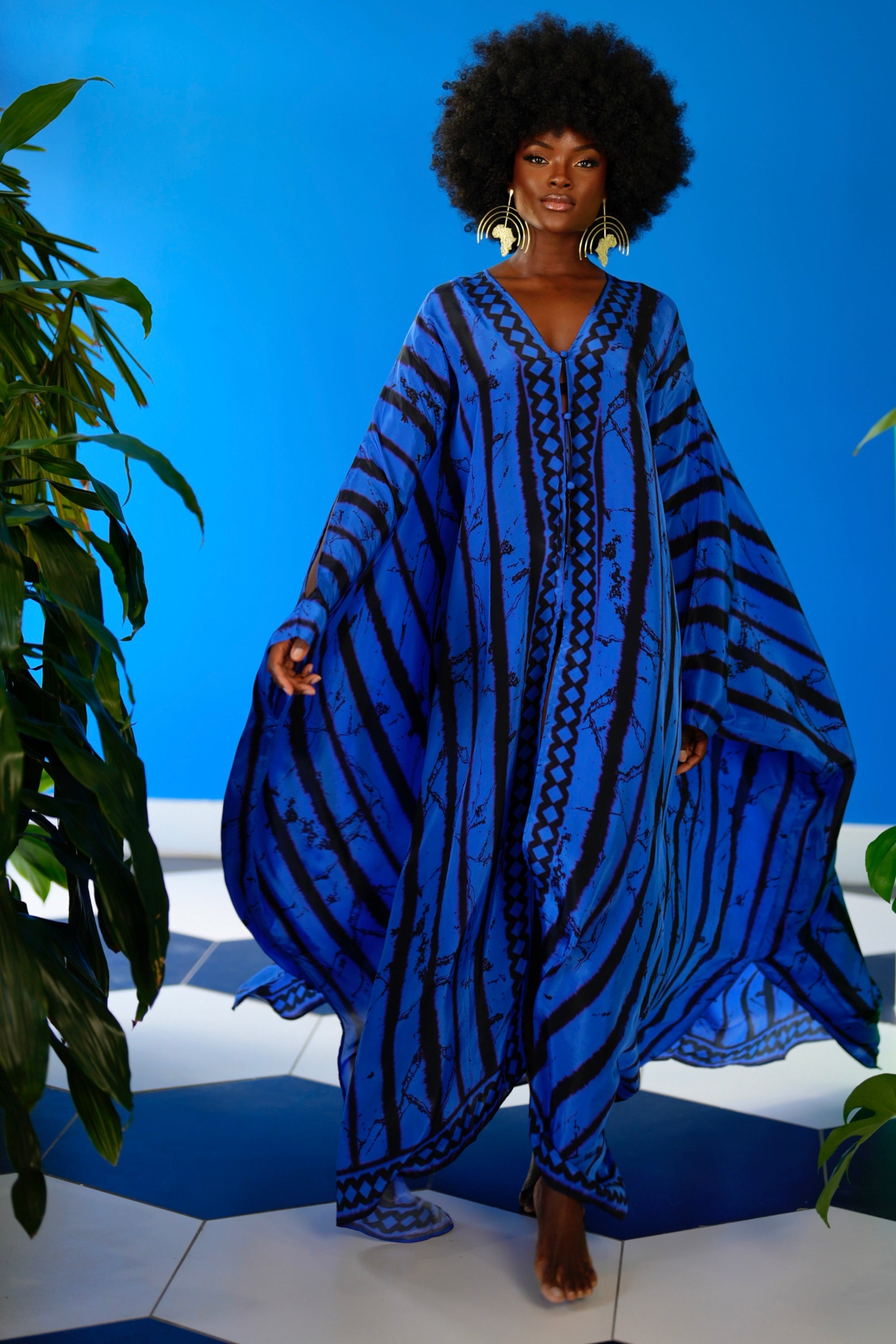 Woman wearing a blue and black patterned dress against a blue background
