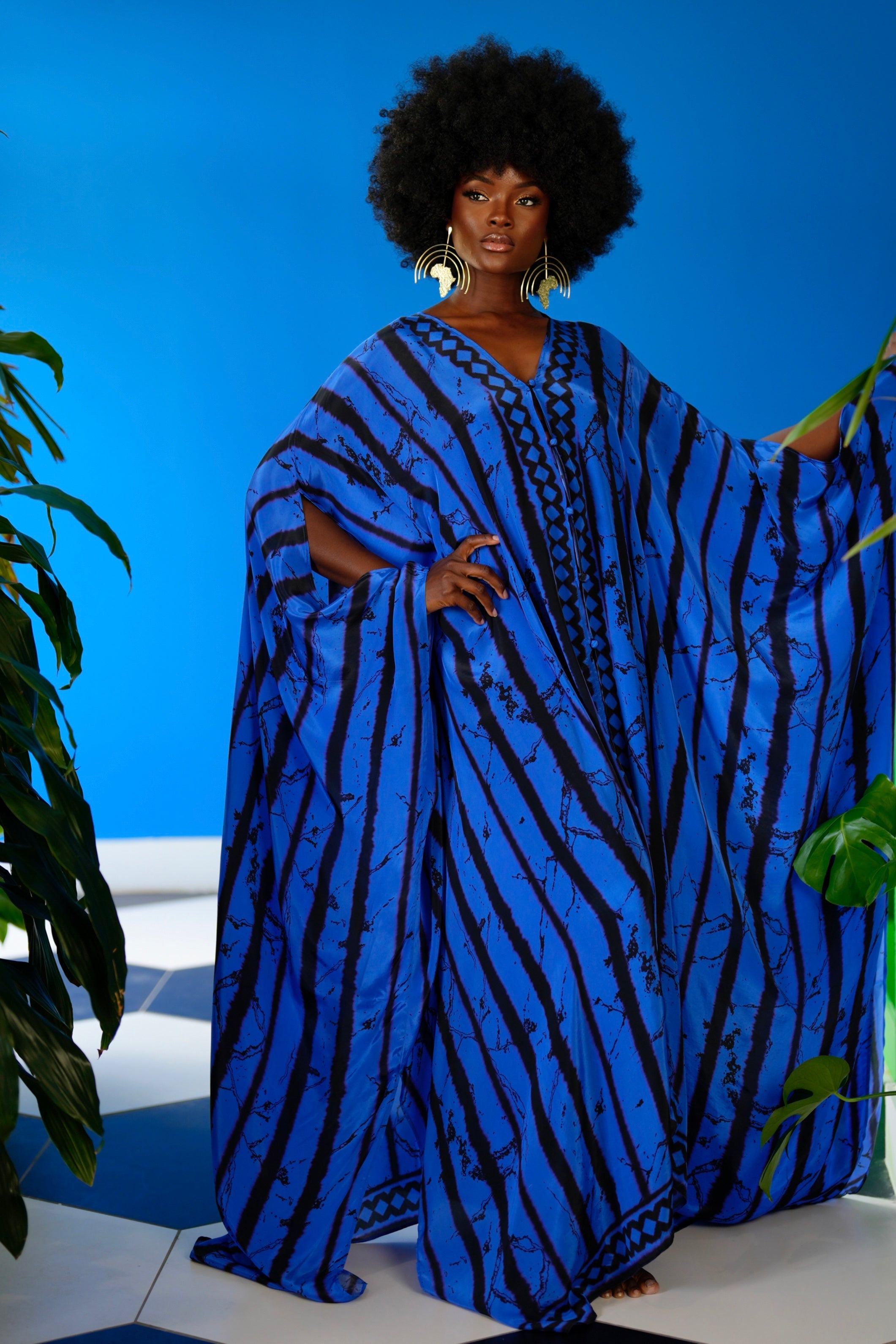 Woman wearing a blue and black patterned dress against a blue background