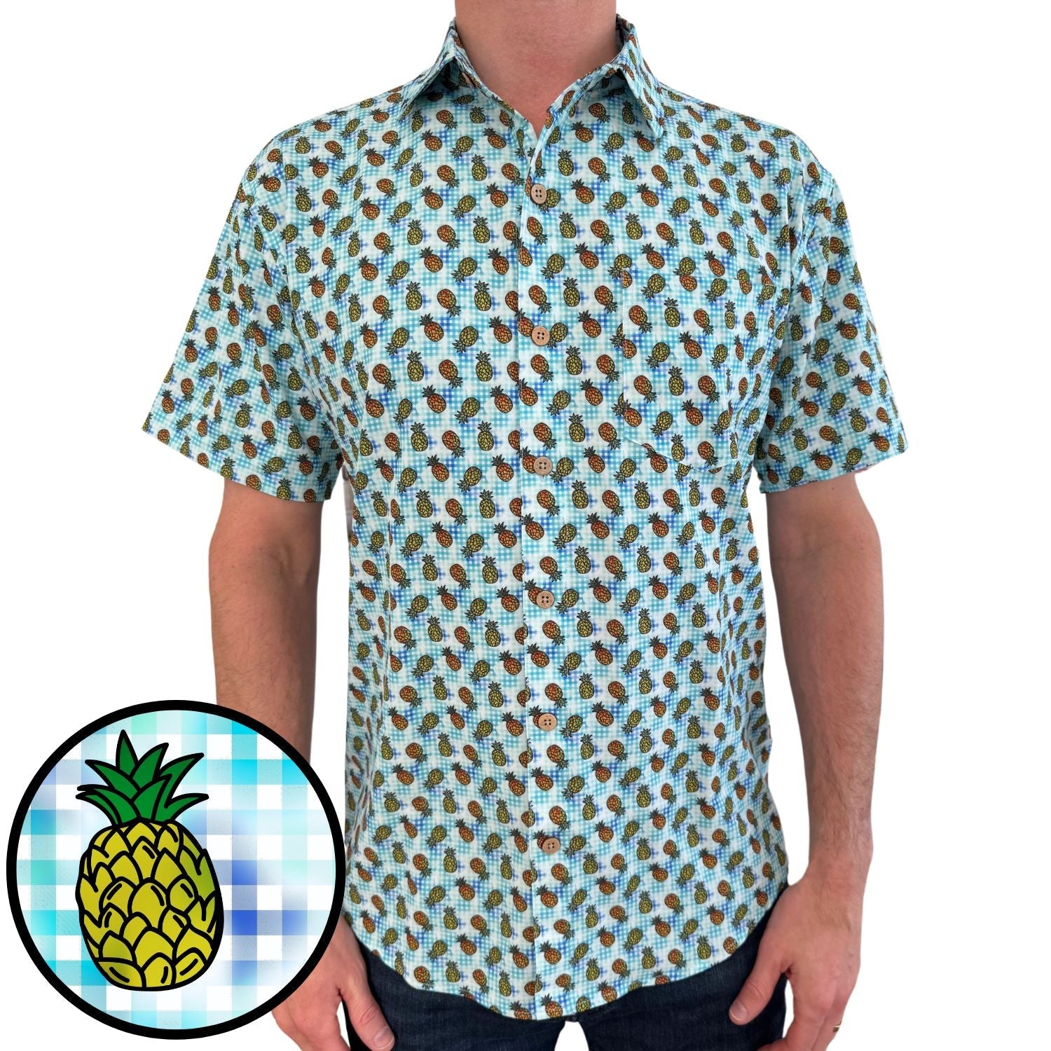 Person wearing a short-sleeve shirt with pineapple pattern on a white background