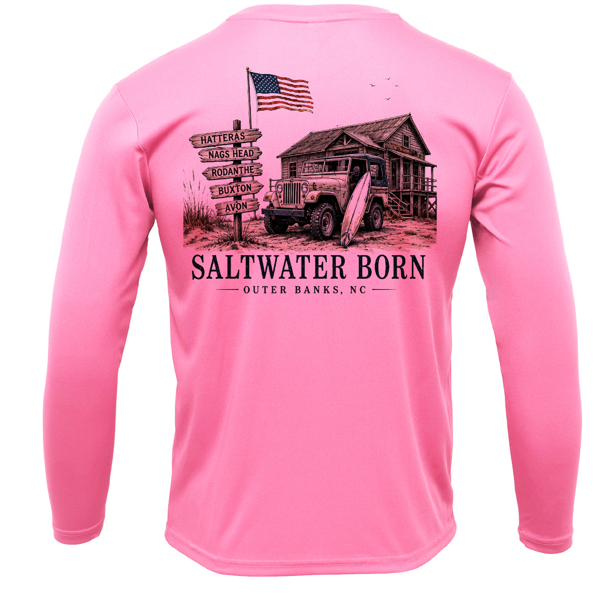 A pink long-sleeve t-shirt shown from the back, featuring a large graphic print of a vintage military jeep, a rustic cabin, an American flag, and a directional signpost with 'SALTWATER BORN' and 'OUTER BANKS, NC'.