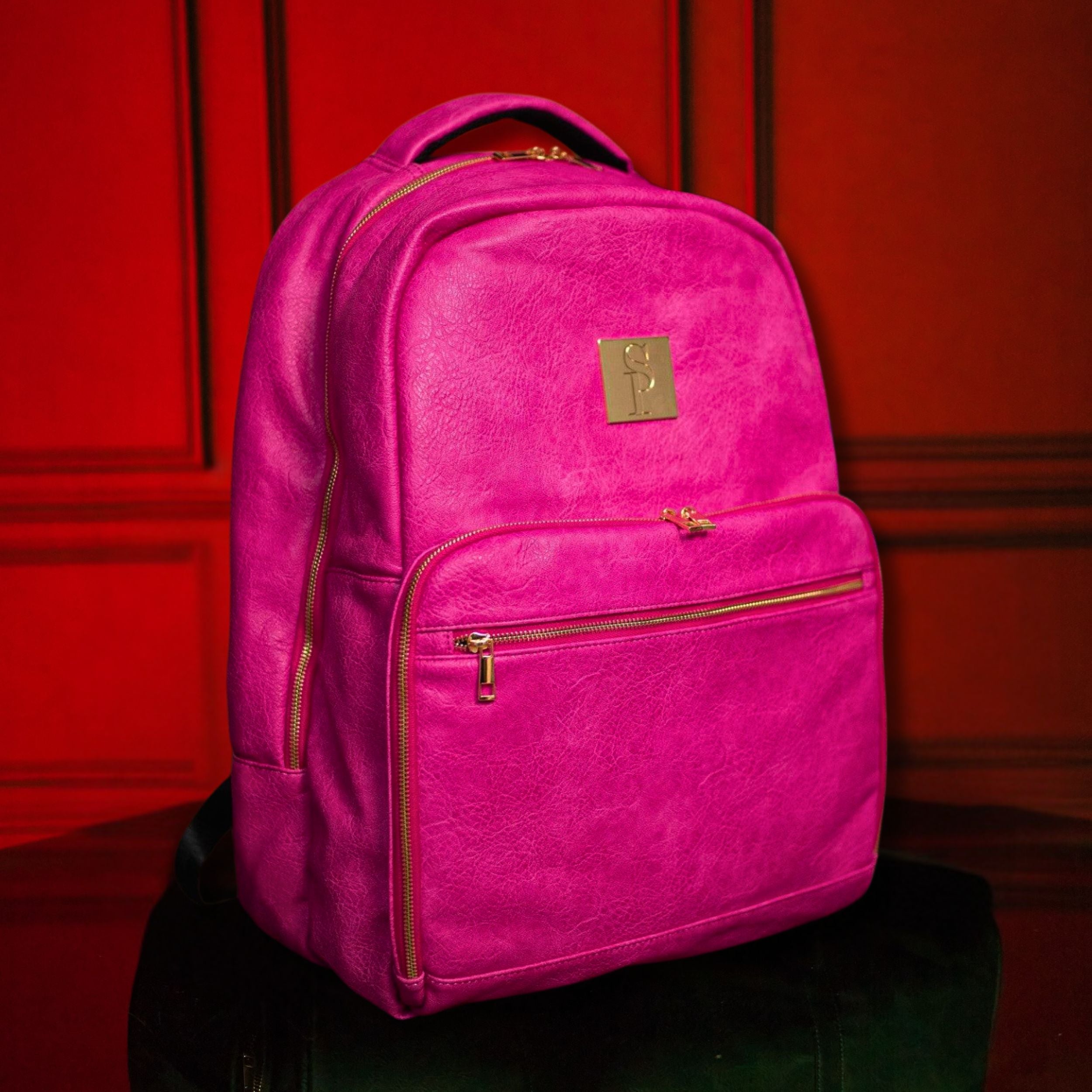 Pink backpack with gold zippers on a red background