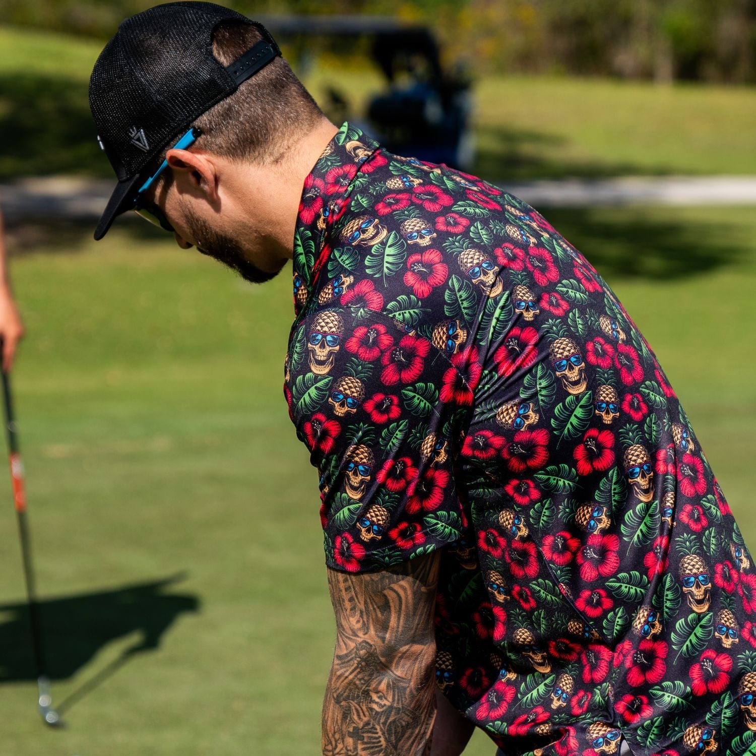 Man wearing a colorful floral shirt on a golf course