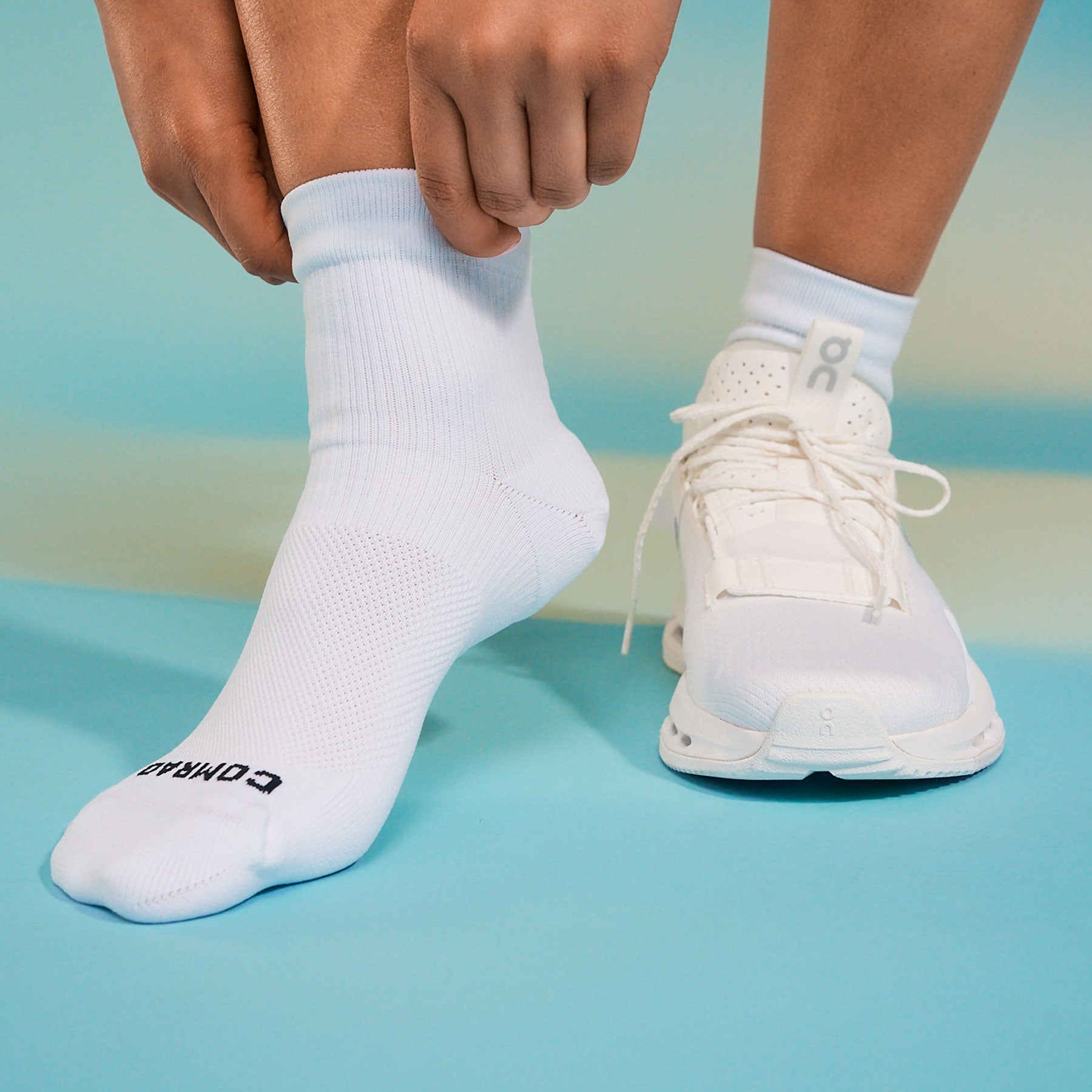 Person wearing white socks and shoes on a gradient background