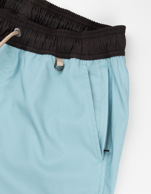Light blue pants with a black waistband on a white background