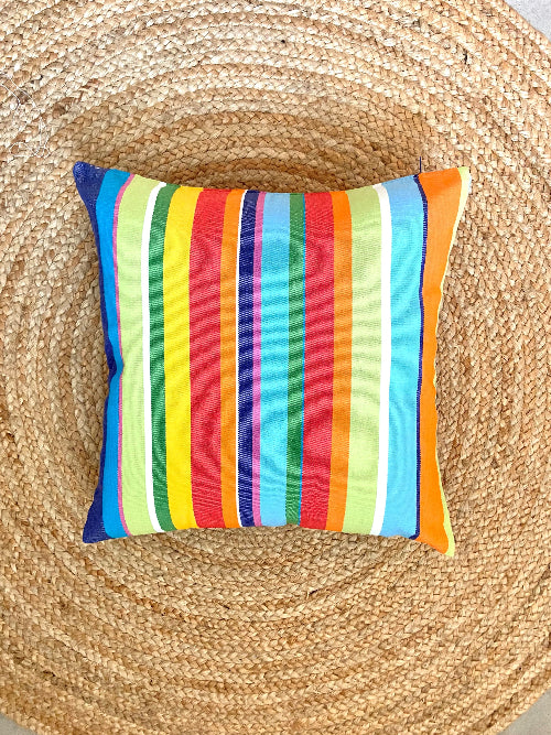 Colorful striped pillow on a woven surface