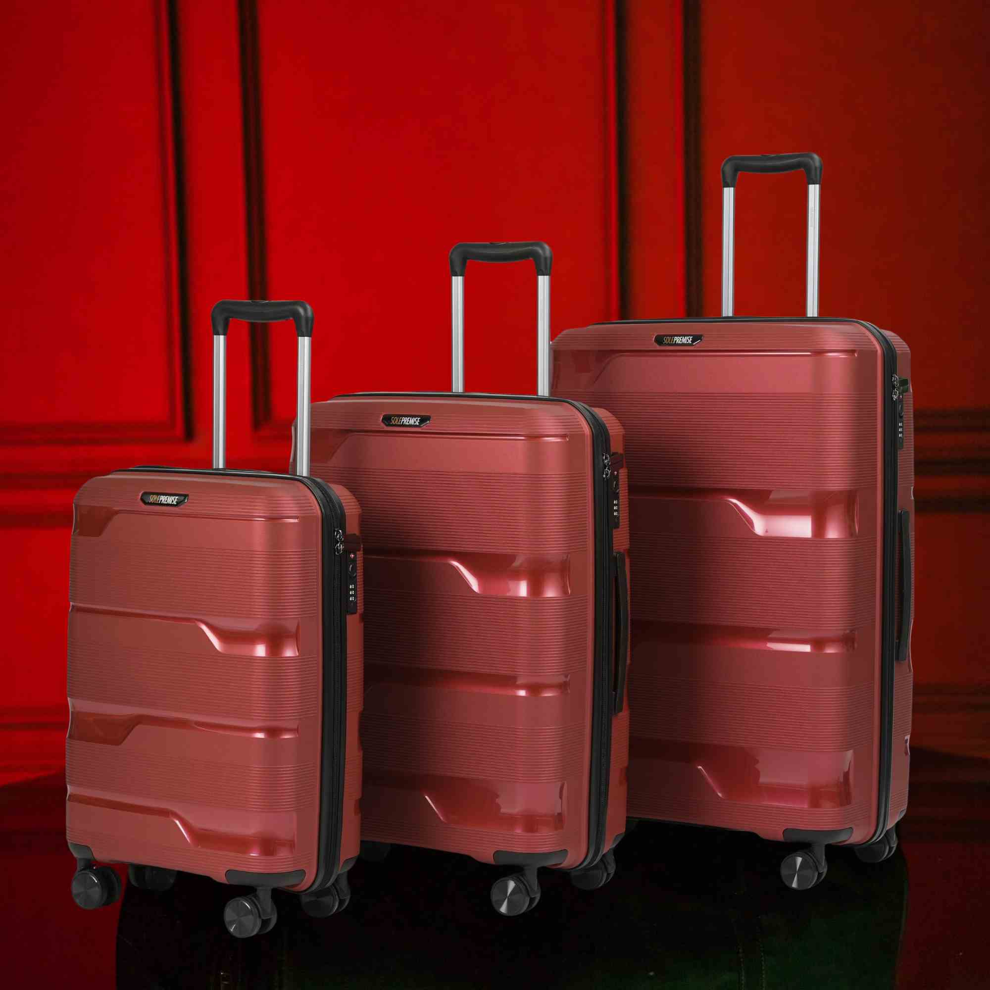 Three red suitcases of different sizes against a red background