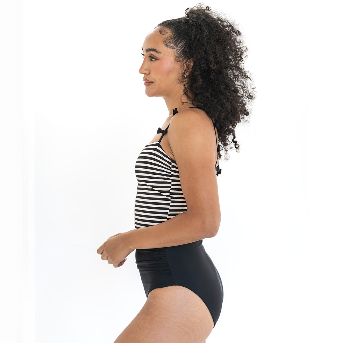 Woman wearing a black and white striped swimsuit on a white background