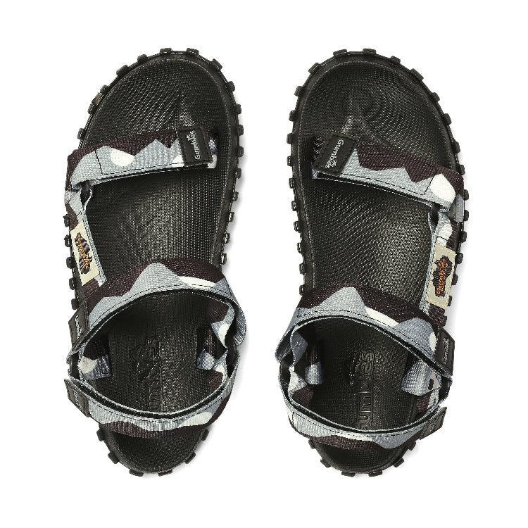 Black and gray sandals with unique sole design on a white background