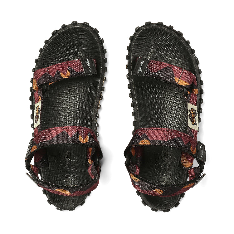 Black sandals with patterned straps on a white background