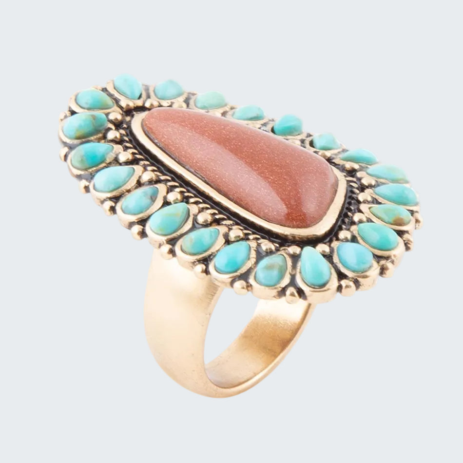 Ring with turquoise stones and a central brown stone on a white background