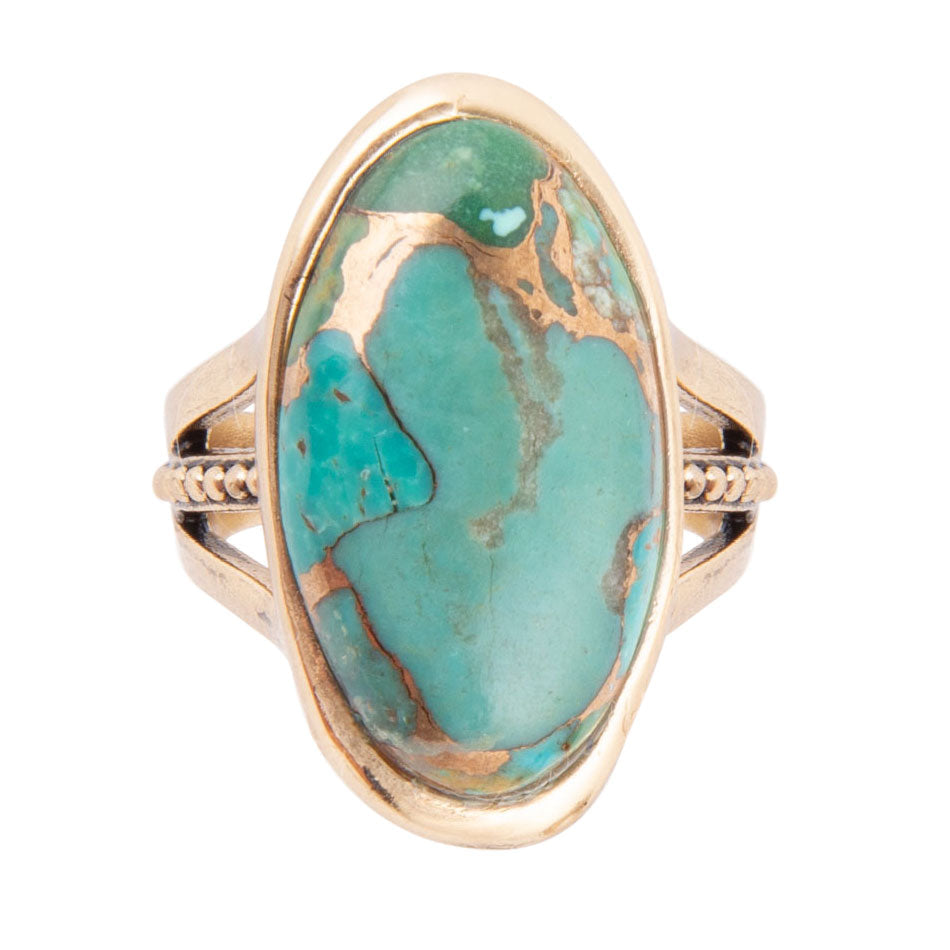 Ring with a large turquoise stone and gold band on a white background