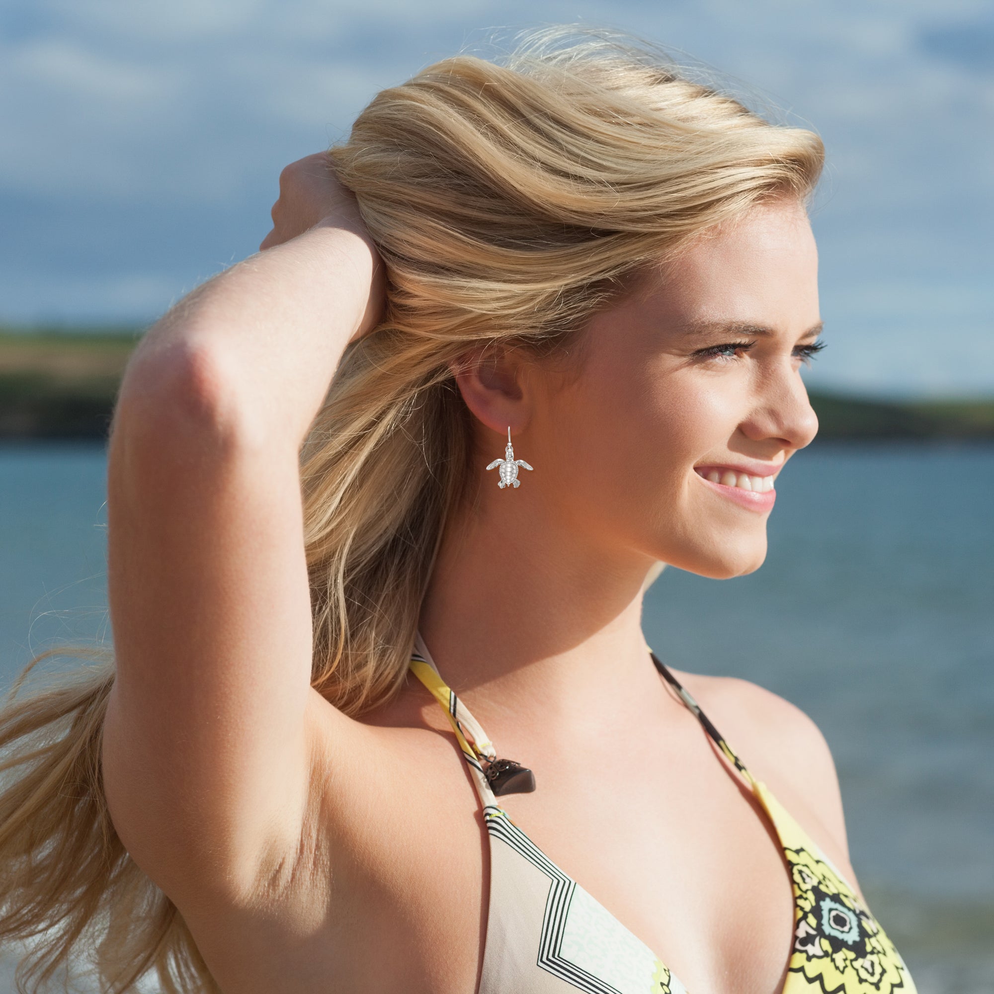 Woman in a bikini top with ocean and sky in the background