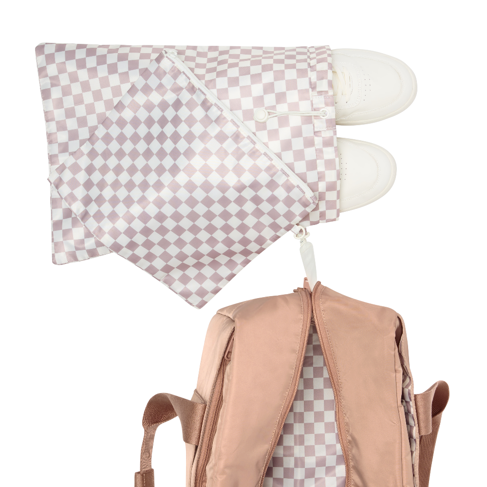 Checkered pink and white pillow with white slippers on a white background