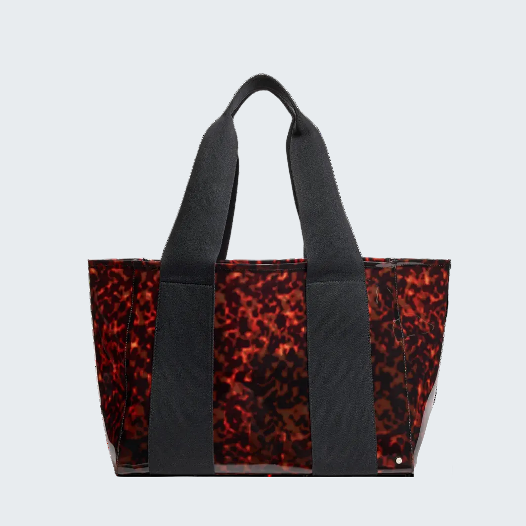 Tortoiseshell patterned tote bag with black handles on a white background