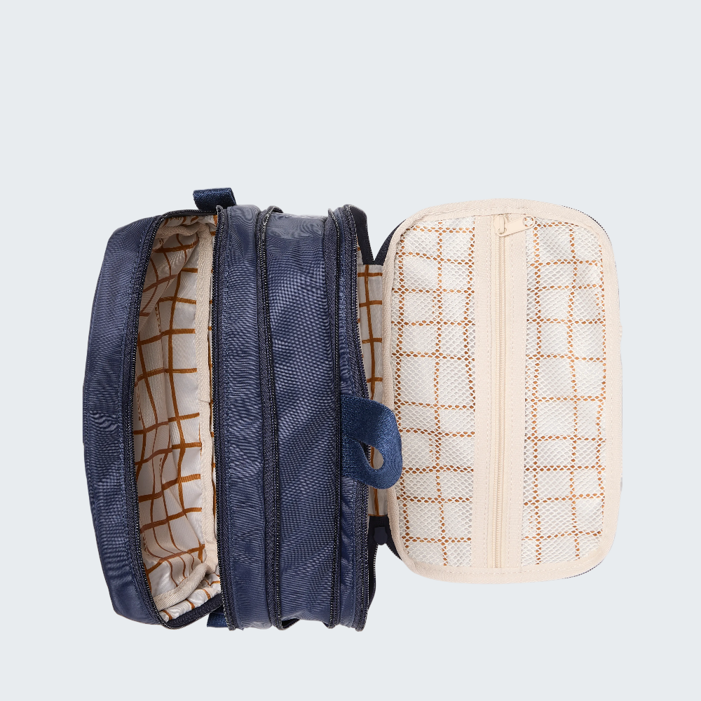 Blue backpack with a beige grid-patterned pouch on a white background