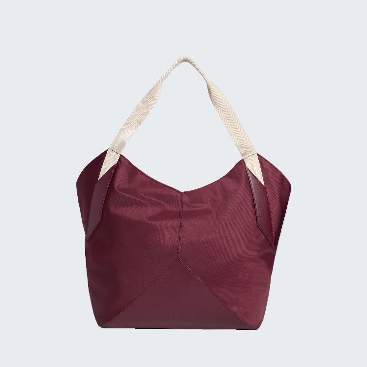 A structured hobo-style tote bag in deep burgundy with cream-colored shoulder straps, shown against a plain white background.