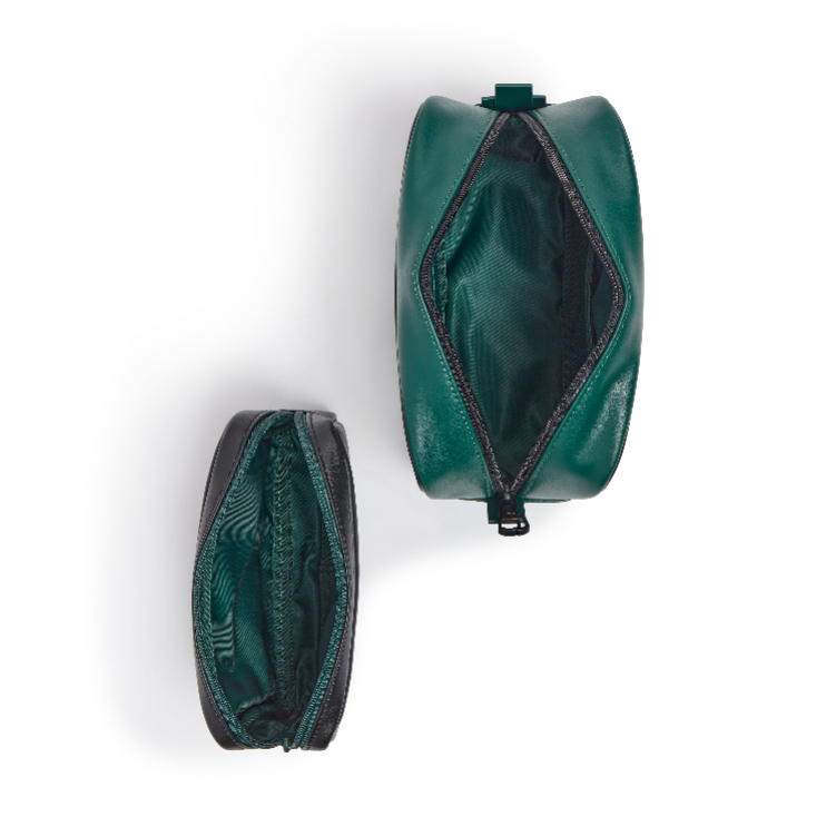 Two dark green zippered pouches shown from above on a white background, one standing upright and one lying on its side, both open to reveal a black interior.