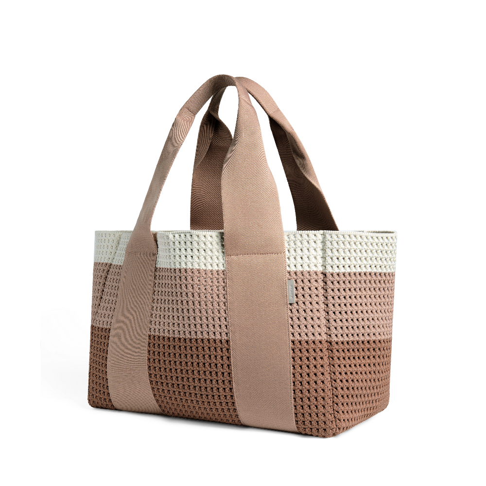 Tote bag with woven pattern and brown handles on a white background