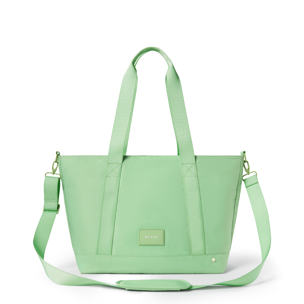 Light green tote bag with a shoulder strap on a white background