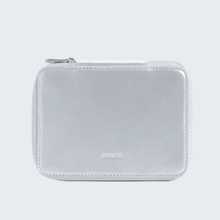 A small metallic silver zippered pouch with rounded corners and a debossed 'STAYEE' logo on the front, set against a solid white background.