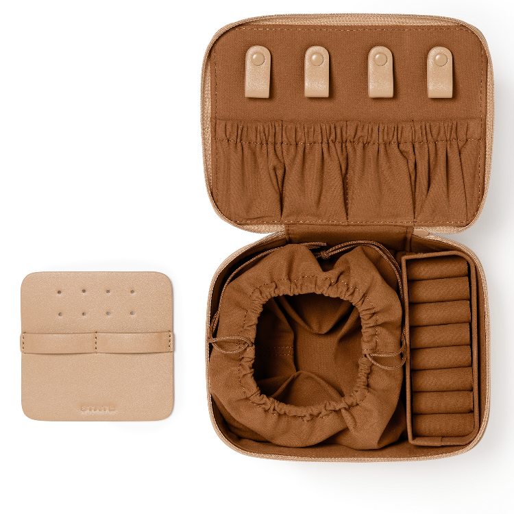 An open brown jewelry organizer case shown on a white background, with a smaller matching closed case placed to the left. The open case reveals interior compartments including a drawstring pouch, ring slots, and a side organizer, in a warm tan-brown tone.