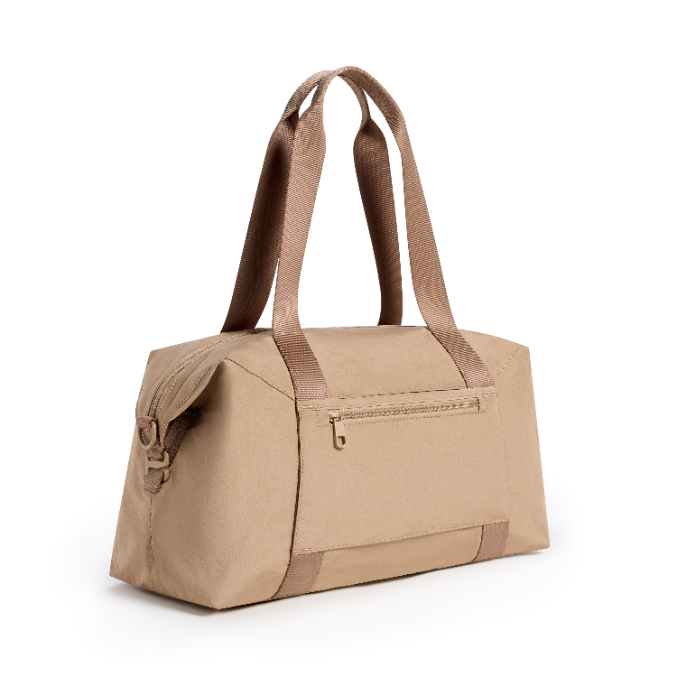 A beige duffel bag with brown handles and trim, shown from a three-quarter angle on a white background.