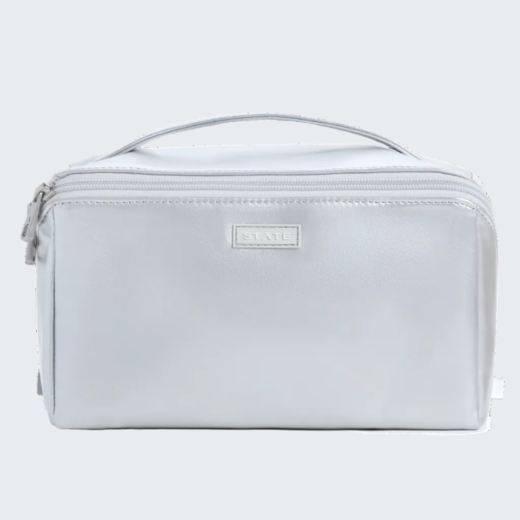 A light gray rectangular toiletry bag with a top handle, zippered closure, and a small metallic brand plaque reading 'DUNGLAND' on the front, shown against a plain white background.
