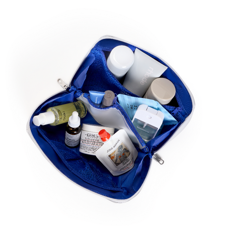 An open blue toiletry bag filled with skincare and beauty products, photographed from above on a plain white background. Visible brands include Kiehl's, The Ordinary, and Zieras.