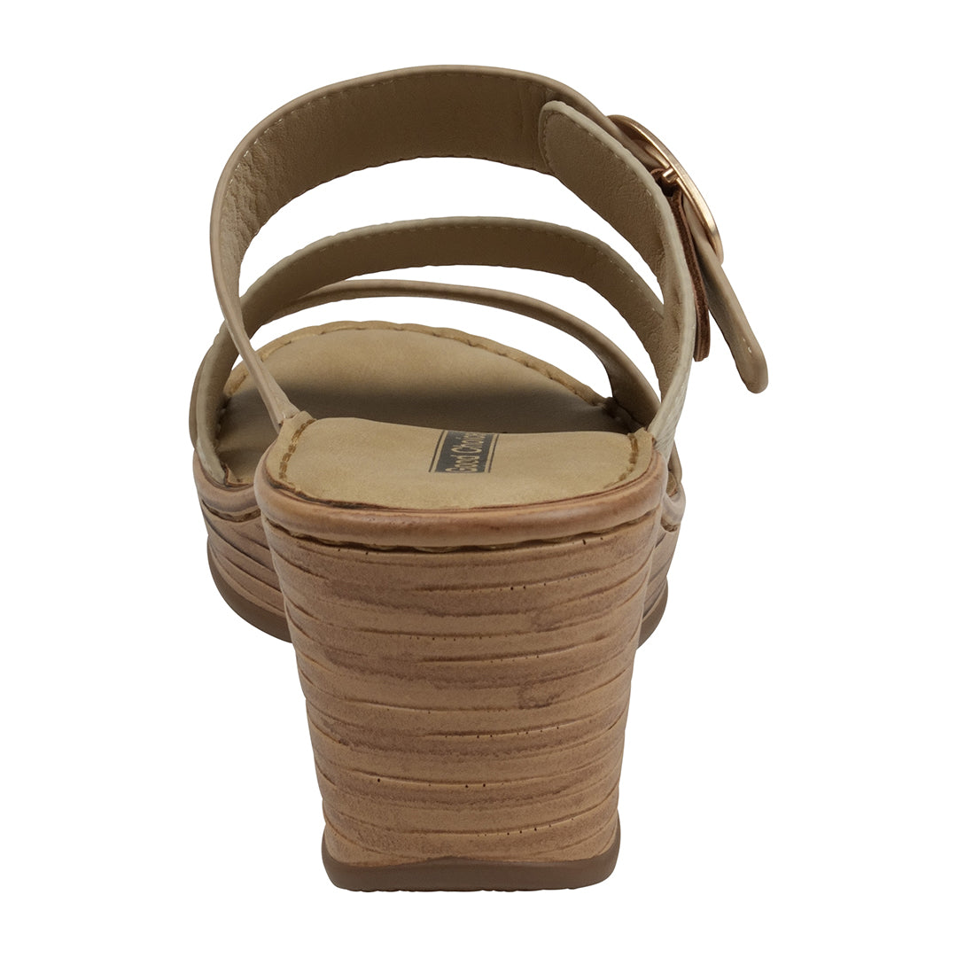 Tan sandal with a textured sole on a white background