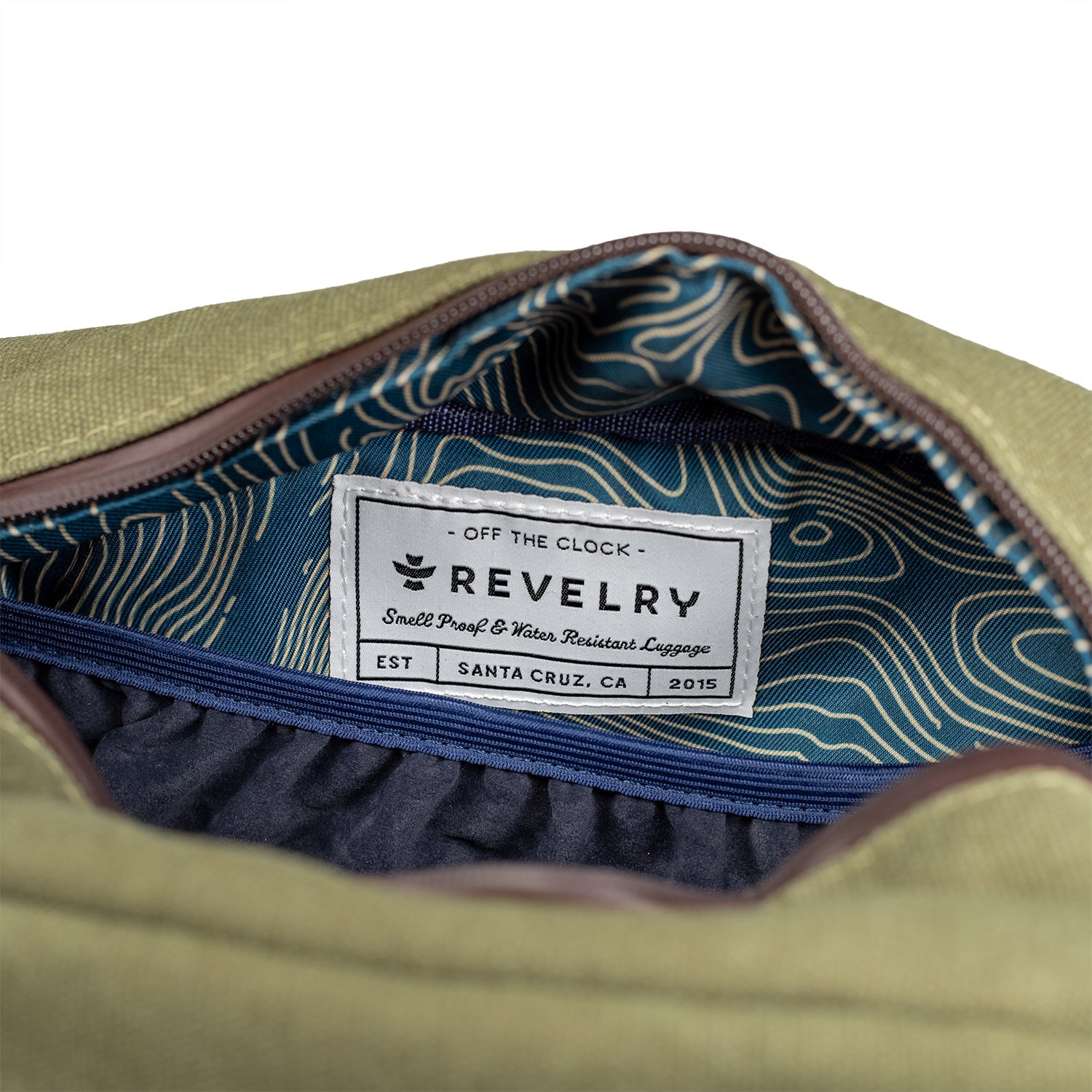 Close-up of a green bag with a Revelry label on a white background