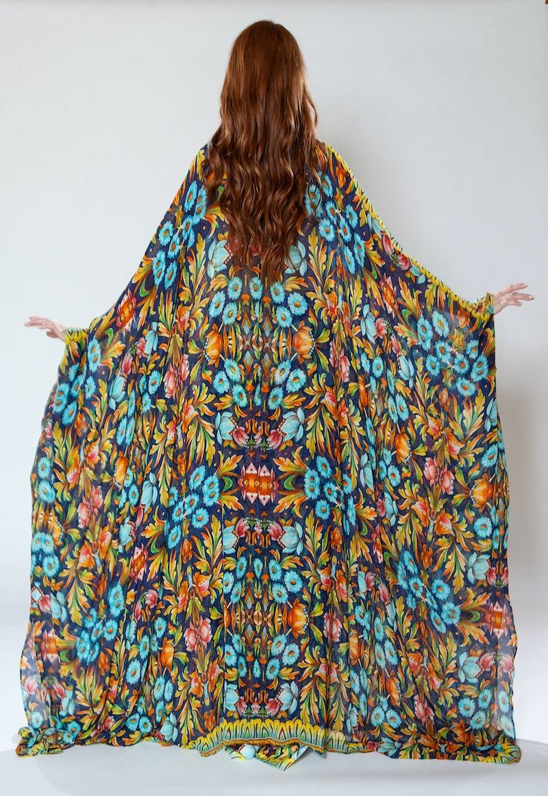 Person holding a colorful floral patterned fabric against a white background