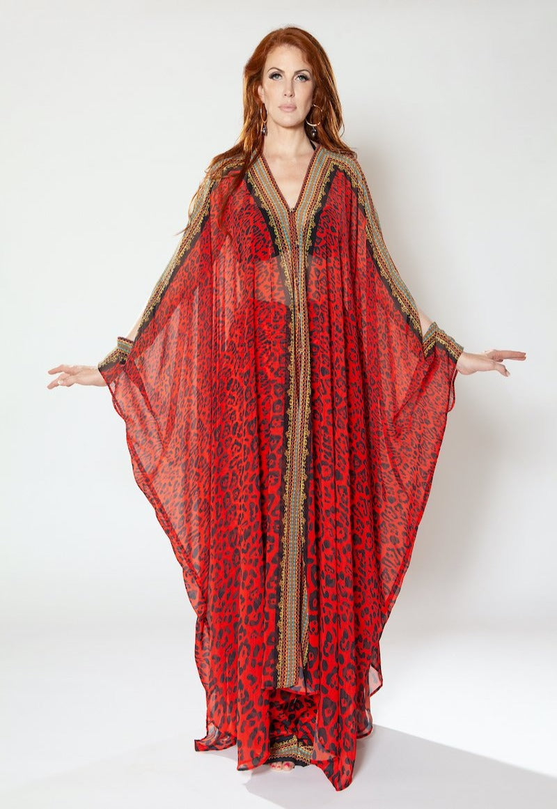 Woman wearing a red and gold patterned dress on a white background